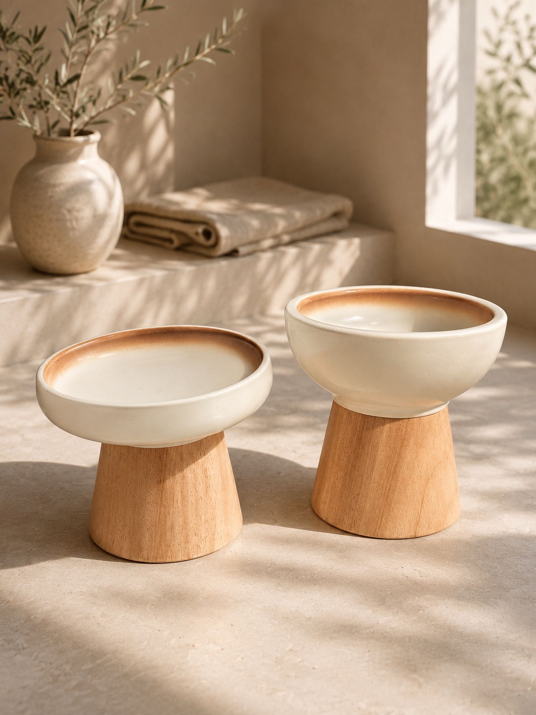 Gamelle d'eau pour chat profonde en céramique sur socle en bois massif, à côté d'une gamelle à croquettes